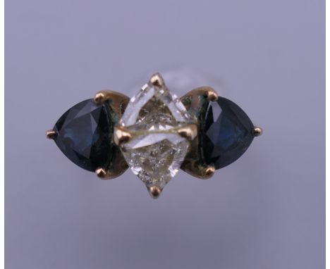 An 18 K gold diamond and sapphire ring. Ring size K. 3.3 grammes total weight.