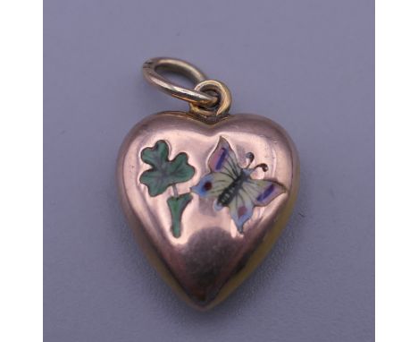 An Edwardian 9 ct gold heart shaped pendant set with enamel butterfly and clover. 1.5 cm high. 1 gram total weight.