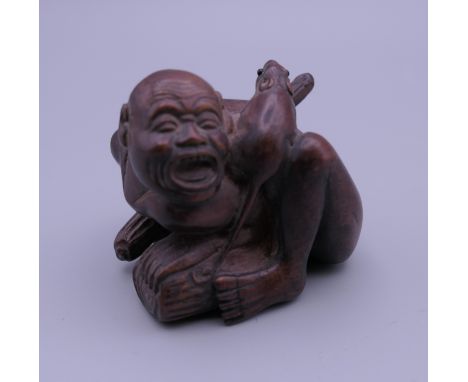 A carved wooden netsuke formed as a man and a rat. 5 cm high.