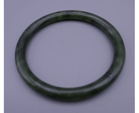 A jade bangle. 8 cm diameter exterior.