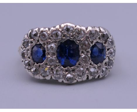 An unmarked gold, diamond and sapphire ring. Ring size O. 4.9 grammes total weight.