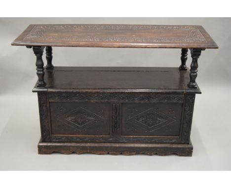 A Victorian carved oak monks bench. 121 cm wide.