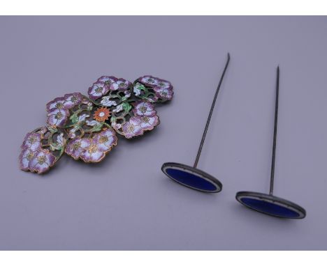 An enamel buckle and two enamel hat pins. 