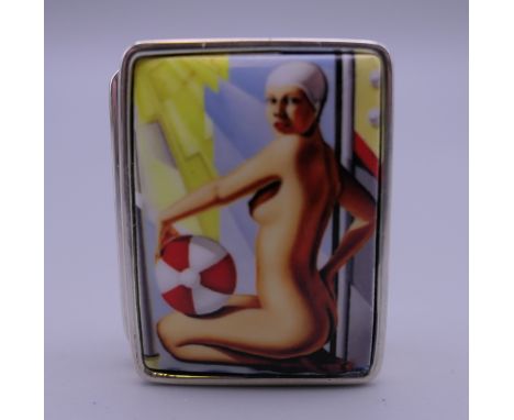 A silver pill box depicting a nude. 3 cm wide.