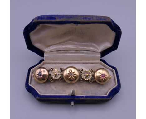 A Victorian unmarked gold, diamond, ruby and sapphire brooch. 5.5 cm wide. 7.9 grammes total weight.