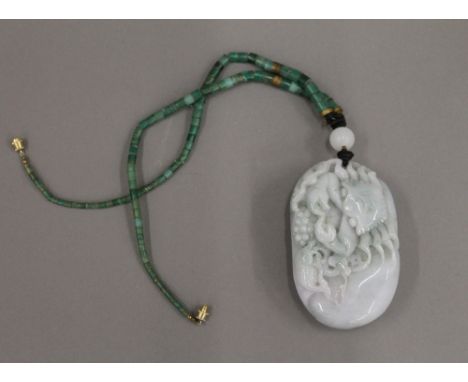 A carved Chinese jade pendant pebble and bead necklace