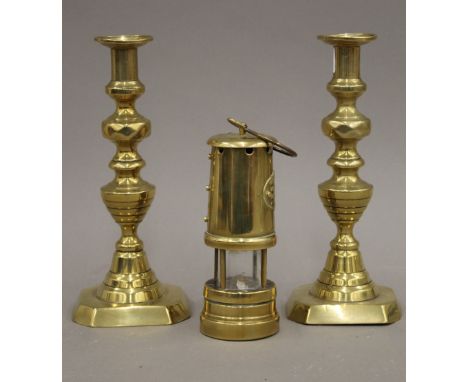 A pair of 19th century brass ejector candlesticks and a miner's type lamp