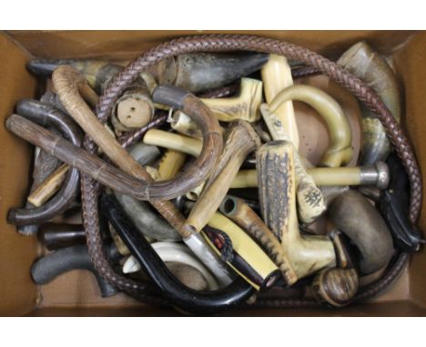 A suitcase containing a collection of walking stick and parasol handles, etc.