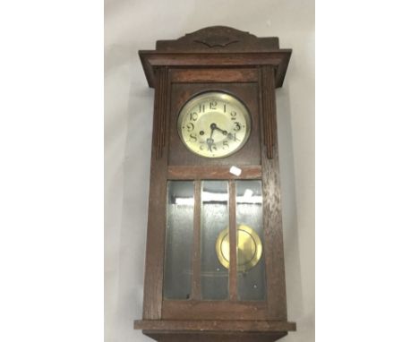 An early 20th century oak wall clock