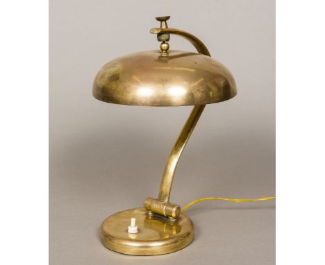 An early 20th century Continental brass desk lamp, the umbrella shade supported on an adjustable arm, standing on a plinth ba