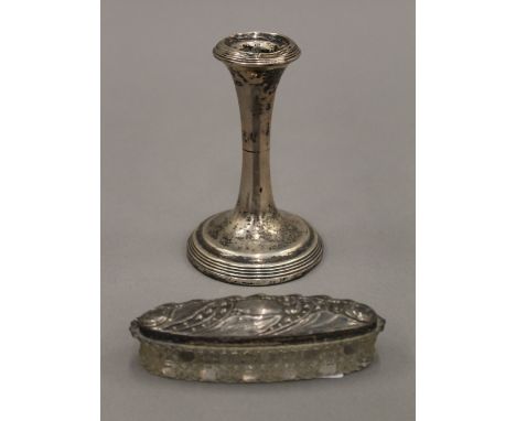 A silver candlestick and an embossed silver topped cut glass jar