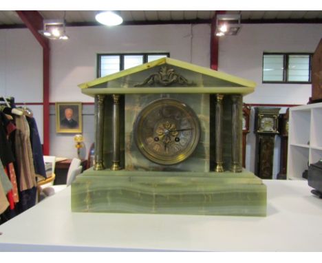 A late Victorian green onyx mantel clock, with brass Roman numerals to the brass face, the 8-day movement striking on a gong;