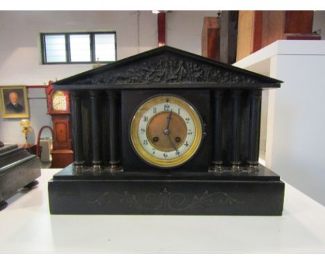 A late Victorian black slate mantel clock, with black Arabic numerals to the cream chapter ring, the 8-day movement striking 