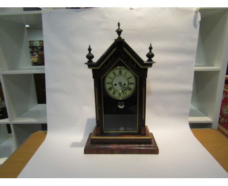 A late 19th Century American style mantel clock, with black Roman numerals to the cream face, the 8-day movement striking on 