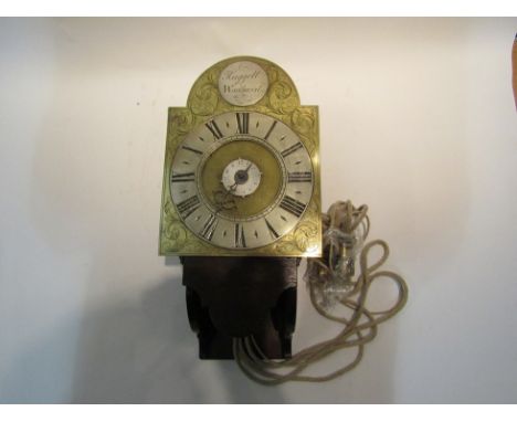 A wall hanging alarm clock, with black Roman numerals to the 16.5cm diameter silvered chapter ring, with brass arched face an