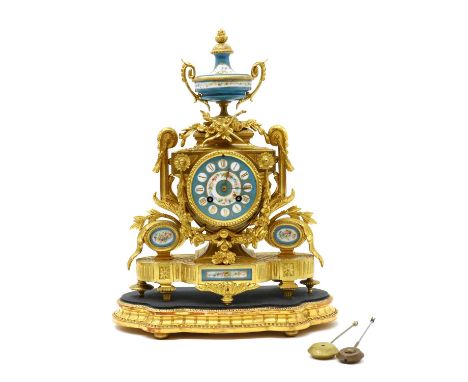 A gilt bronze table clock,late 19th century, French, with a Sevres style porcelain urn, dial and panels, cast with trophies, 