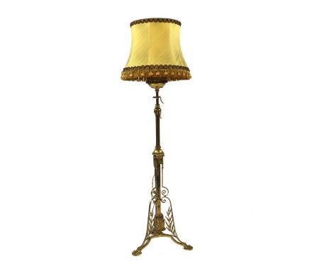 A brass standard lamp,with an adjustable telescopic column, stiff leaf mounts, paw feet and a copper reservoir, converted to 