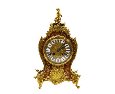 A red boulle mantel clock,late 19th/early 20th century, French, with cast brass mounts, porcelain numerals and a drum movemen