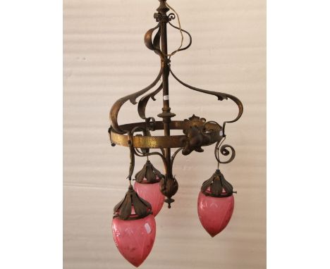 An Art Nouveau brass hanging ceiling light the central pole/stem supporting a ring and whiplash scrolling organic leaf detail