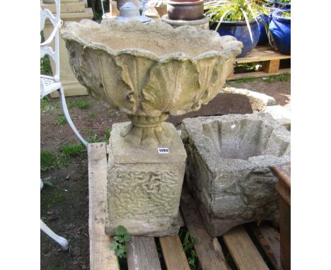 A weathered composition stone garden urn of circular form with cabbage leaf bowl, socle and square plinth, approx 50 cm diame