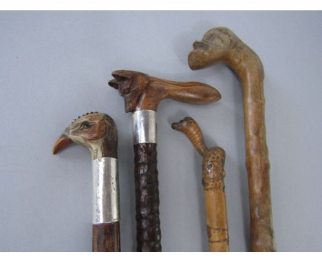 Four good antique walking canes to include a naturalistic carved crooked handle cane with a carved bearded gentleman knop; to