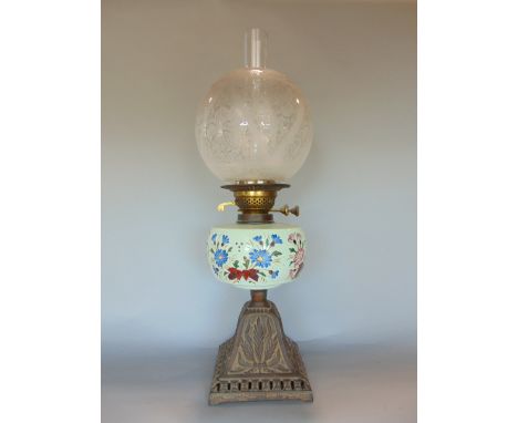 Edwardian cast metal oil lamp with enamelled floral reservoir, 48 cm high including shade