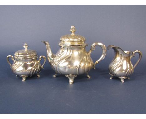 Continental '800' silver three piece tea service of lobed form comprising tea pot, milk jug and lidded sucrier, the tea pot 2