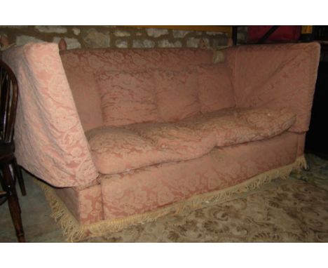 A substantial traditional knoll sofa, upholstered in salmon pink and floral patterned fabric, with loose cushions and drop en