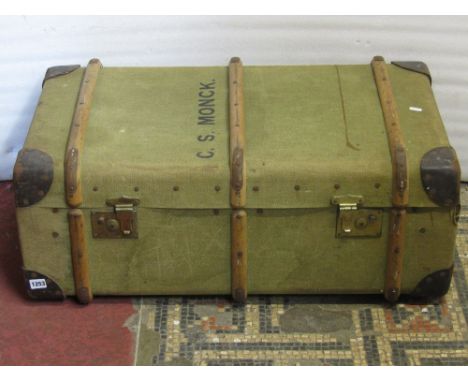 A vintage green canvas travel trunk with timber lathes and brass fittings, complete with key together with two dressing stool
