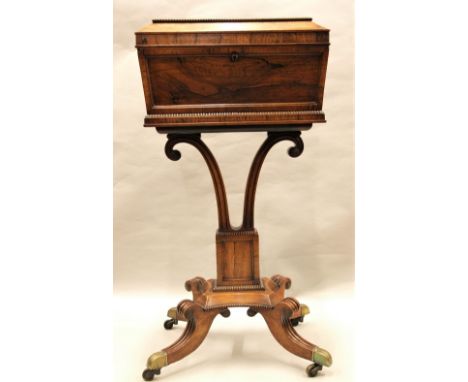 A good Regency rosewood teapoy, the rectangular caddy with segmented interior, raised on a pair of horn shaped supports, pill