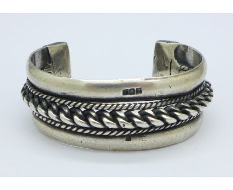 A white metal bangle with continental marks, 101g