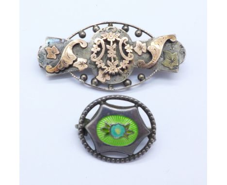 A silver brooch with gold applied decoration and a silver and enamel brooch