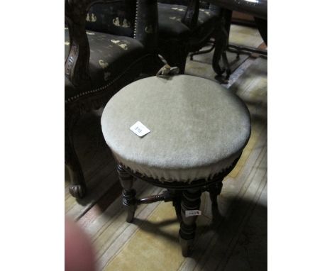 AN EDWARDIAN MAHOGANY REVOLVING STOOL the circular upholstered seat raised on turned legs joined by cross stretchers