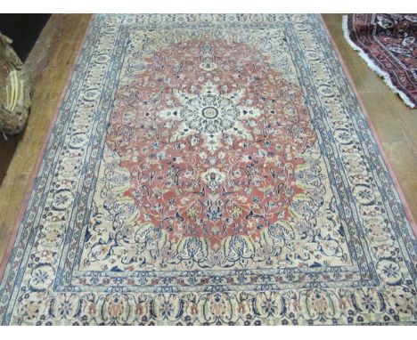 A WOOL RUG the beige and light pink ground with overall floral decoration 236cm x 177cm