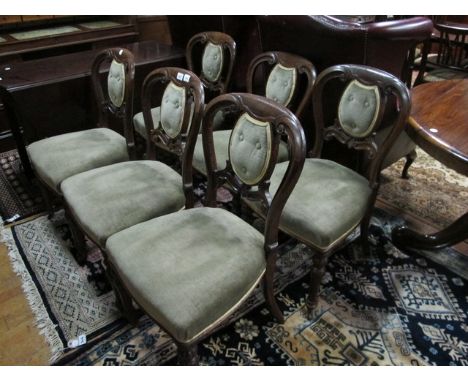 A SET OF SIX VICTORIAN OAK DINING CHAIRS each with a curved top rail above a button upholstered panel and seat on reeded and 