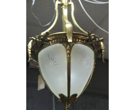 A CONTINENTAL GILT BRASS AND FROSTED GLASS CENTRE LIGHT the circlet hung with stylized foliage decoration above star cut pane