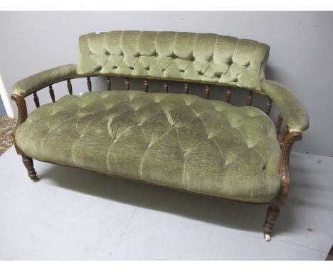 AN EDWARDIAN MAHOGANY SETTEE with button upholstered back and seat with scroll arms on turned legs 140cm wide