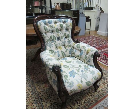 A GOOD VICTORIAN MAHOGANY GENTS CHAIR the curved top rail carved with stylized flowerhead above a deep button upholstered bac