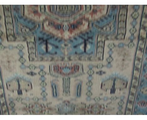 A WOOL RUG the light blue and pink ground with central panel with hooks and palmets within a four stripe border 150cm x 90cm
