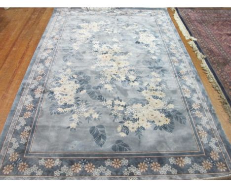 A CHINESE WOOL RUG the light blue ground with central floral panel above a conforming border 185cm x 276cm