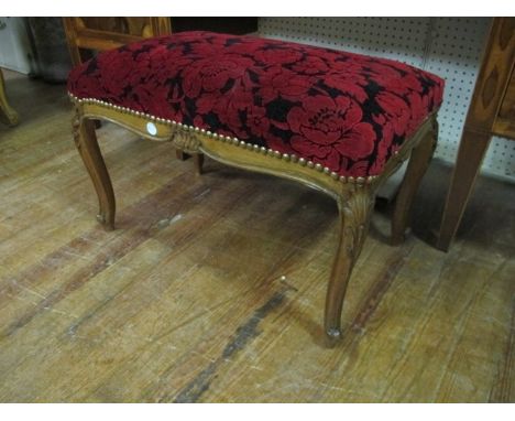 A CONTINENTAL BEECHWOOD AND UPHOLSTERED STOOL the rectangular upholstered seat above a carved apron on cabriole legs