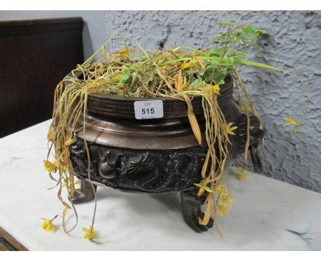 AN ORIENTAL BRONZE PLANTER of circular form the frieze moulded in high relief with dragons figural masks and carrying handles