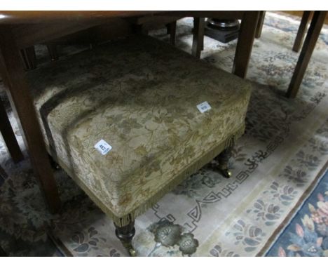 A REGENCY MAHOGANY STOOL the upholstered seat raised on lobed and ring turned legs with brass caps and casters 44cm (h) x 56c