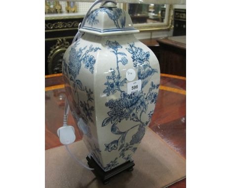 A PORCELAIN TABLE LAMP the white and blue ground decorated with flowerheads and foliage raised on a hardwood base with pleate