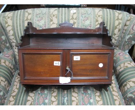 AN EDWARDIAN MAHOGANY WALL MOUNTED CABINET of rectangular form the super structure with moulded shelf above an open compartme
