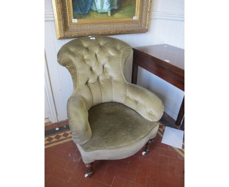 A VICTORIAN MAHOGANY AND UPHOLSTERED CHAIR with deep button upholstered back and seat on turned legs with brass porcelains ca