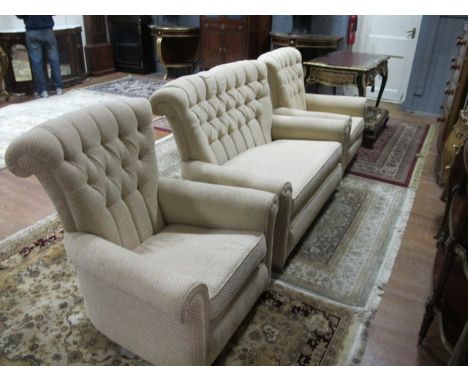 A THREE PIECE SUITE comprising a two seater settee and a pair of easy chairs with deep button upholstered back with loose cus