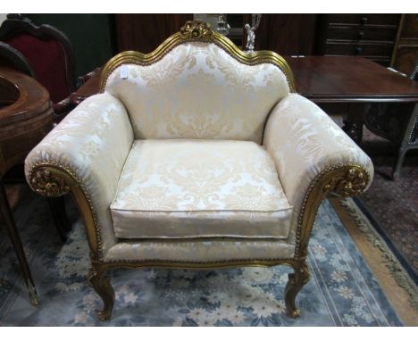 A CONTINENTAL GILTWOOD AND UPHOLSTERED ARMCHAIR the serpentine reeded back with stylized foliate cresting above an upholstere