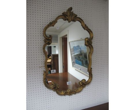 A CONTINENTAL GILT FRAMED MIRROR the C scroll foliate moulded frame together with a mantle clock