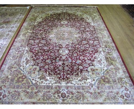 A WOOL RUG the beige ground with central floral panel within a conforming border 285cm x 190cm